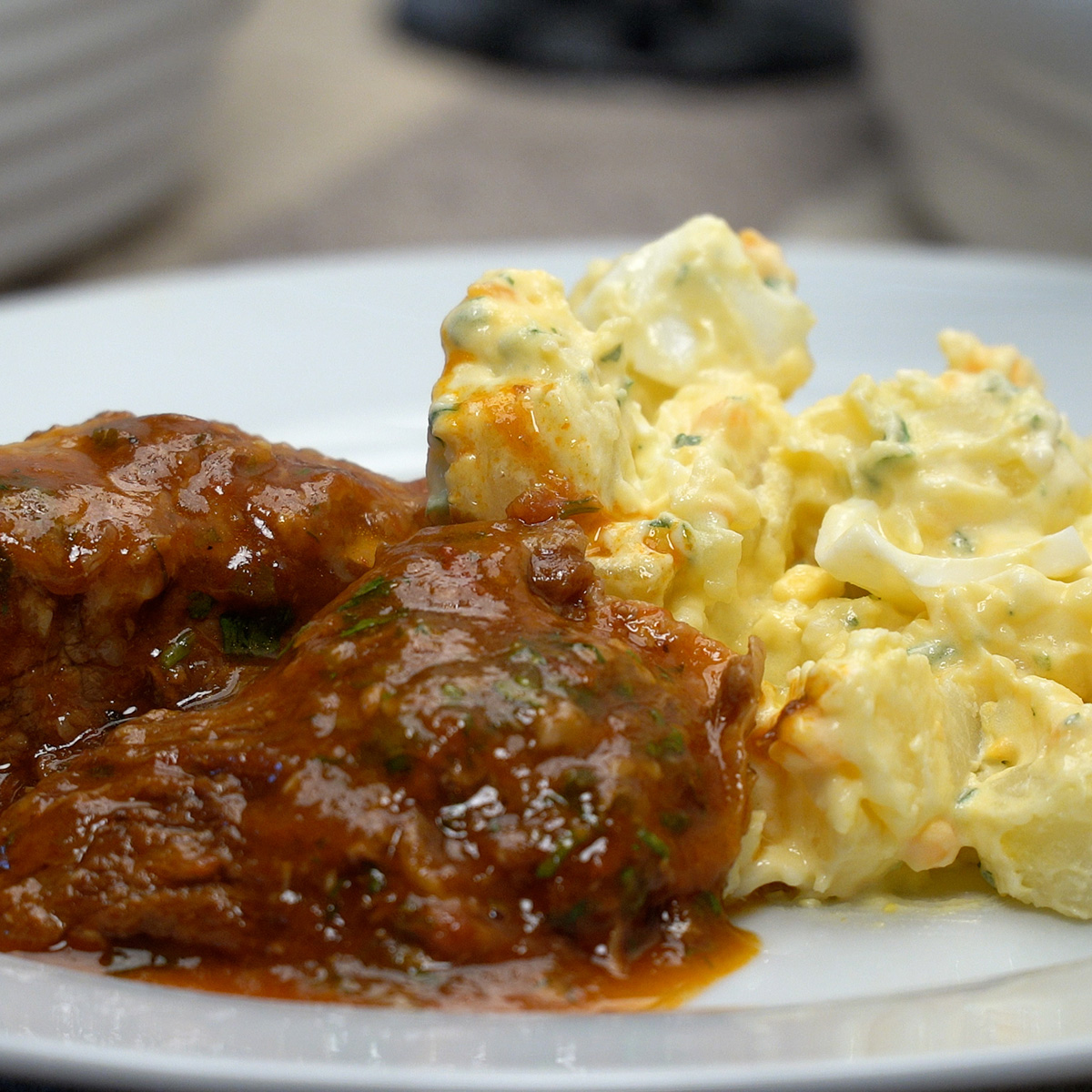 Prato de carne cozida servido com salada cremosa de batata.