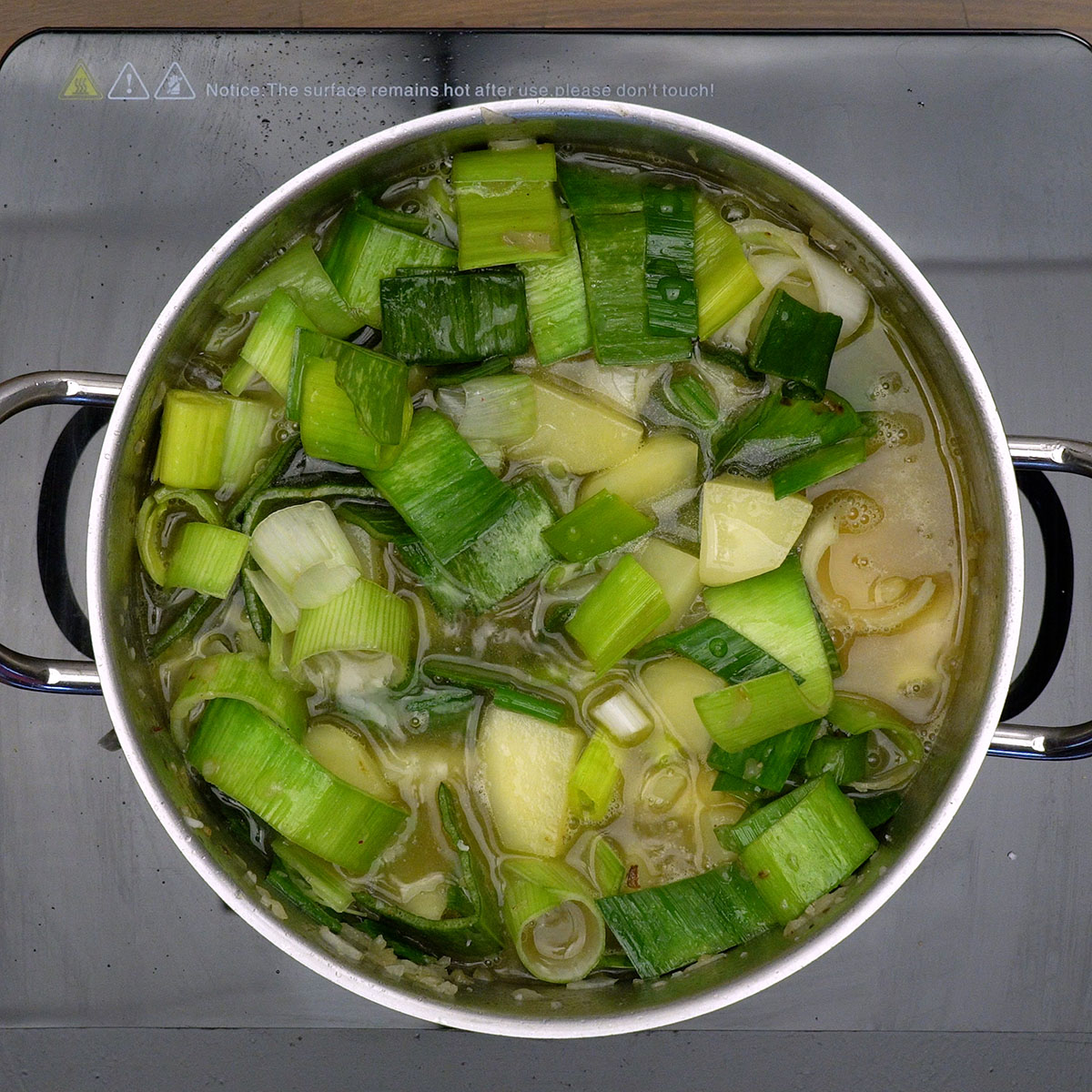 Creme de alho-poró cozinhando com caldo de legumes na panela.