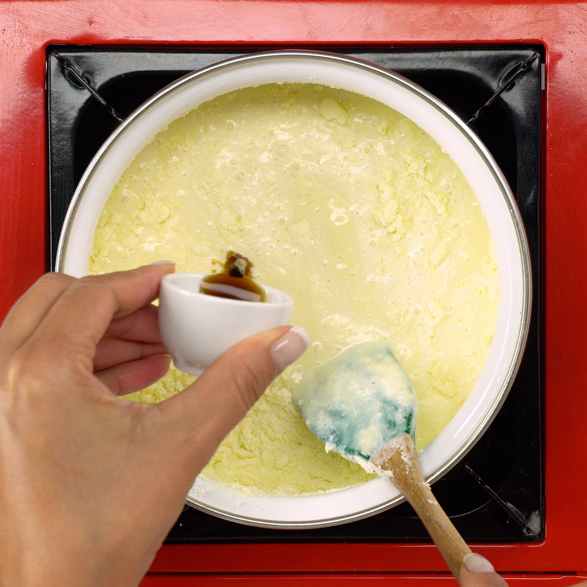 Creme branco recebendo essência de baunilha durante o preparo da sobremesa.