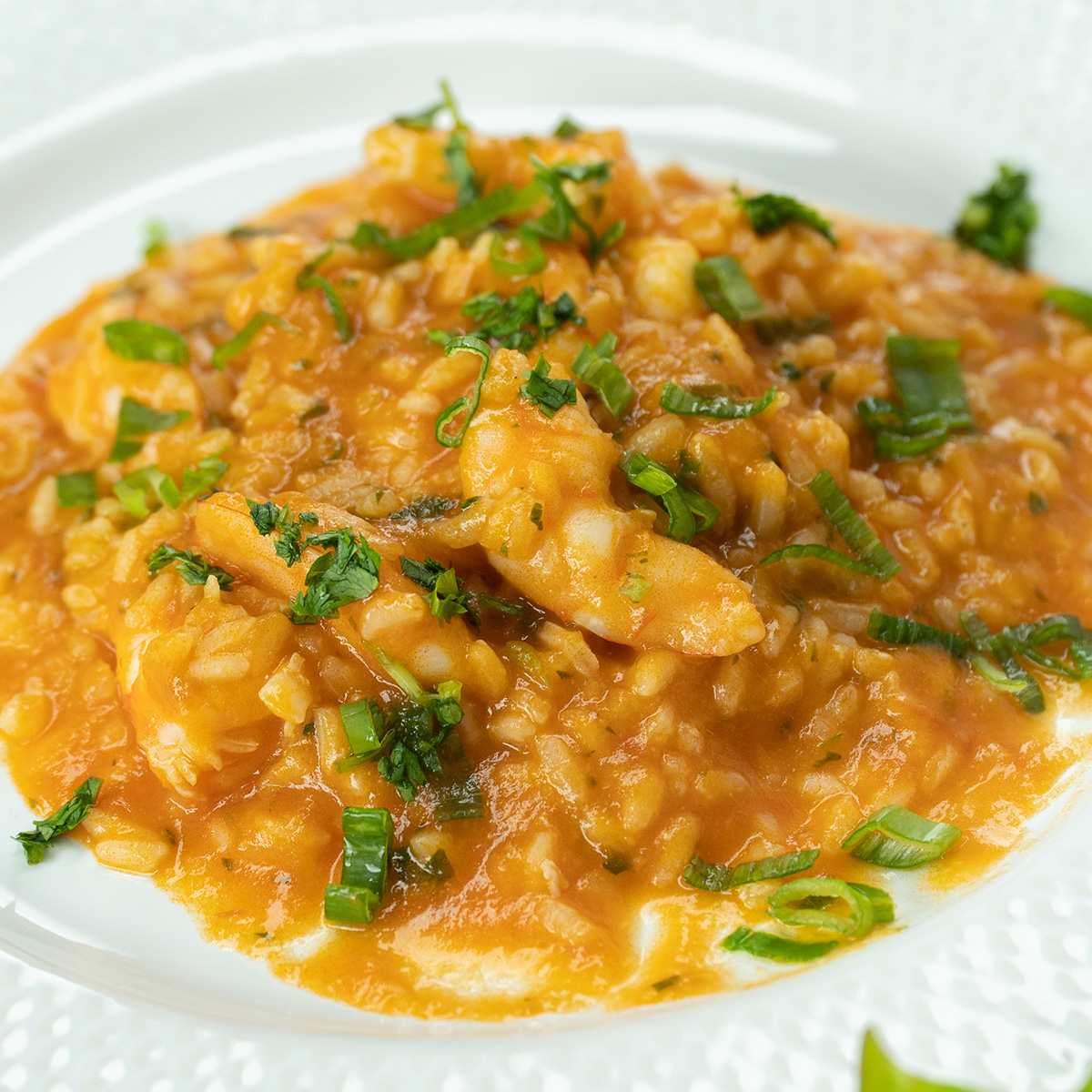 Empratamento arroz de camarão finalizado com coentro por cima.