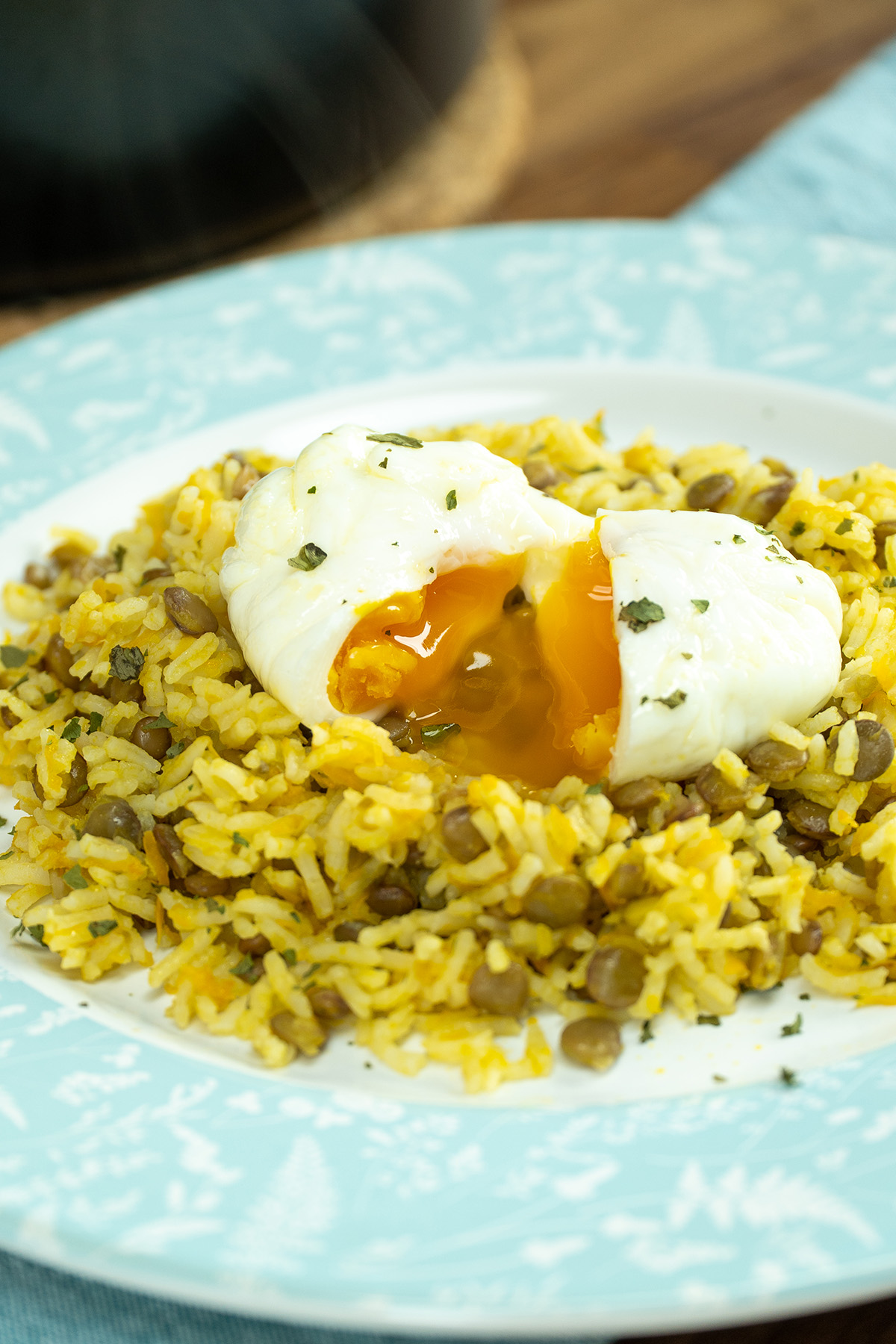 Prato de arroz de lentilhas servido com ovo poché com salsa de decoração.