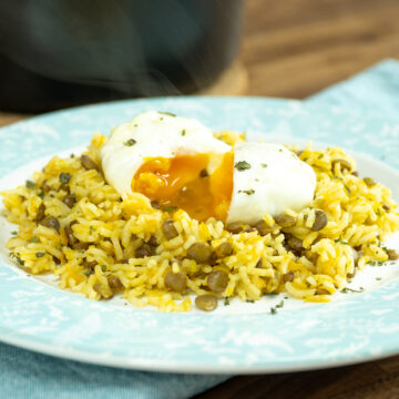 Prato de arroz de lentilhas servido com ovo poché com salsa de decoração.
