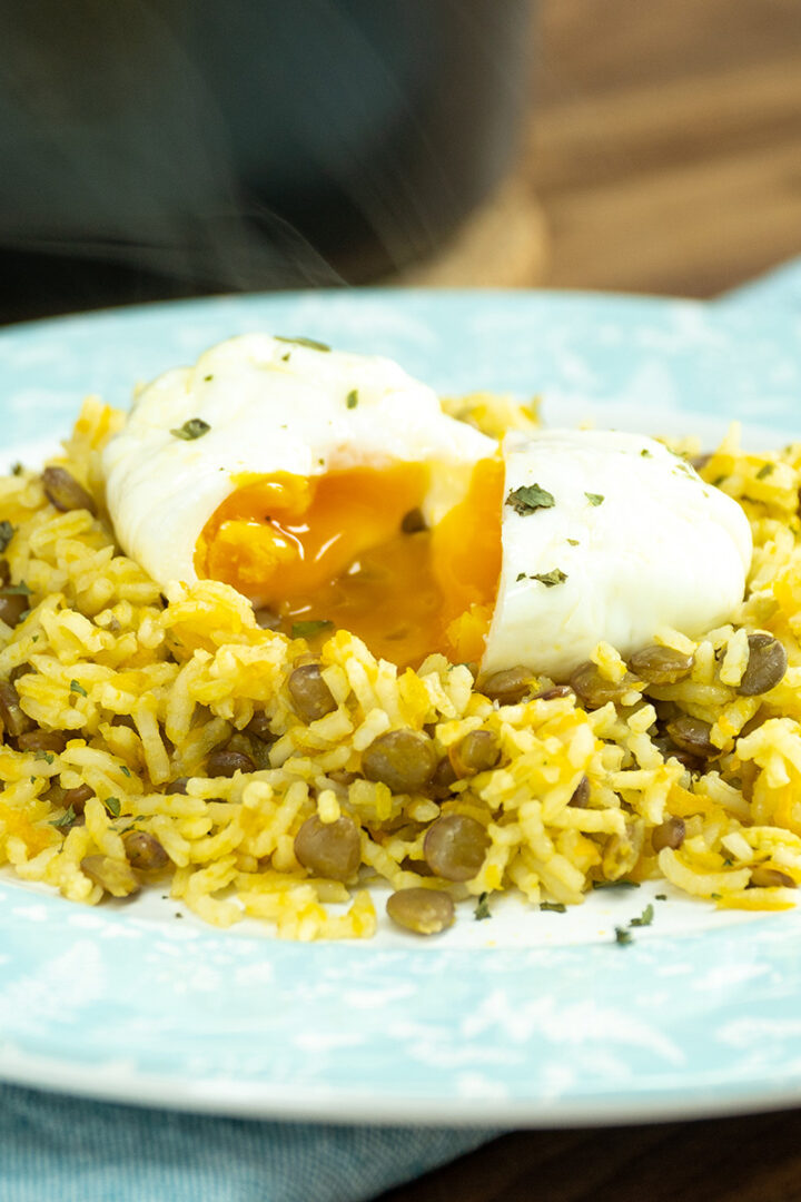 Prato de arroz de lentilhas servido com ovo poché com salsa de decoração.