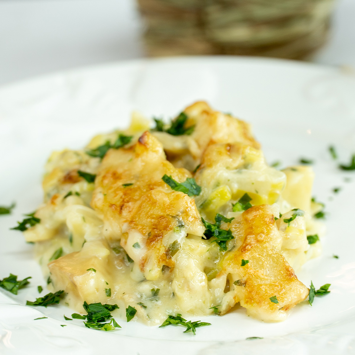 Empratamento bacalhau gratinado com alho-poró com salsa fresca finalizado.
