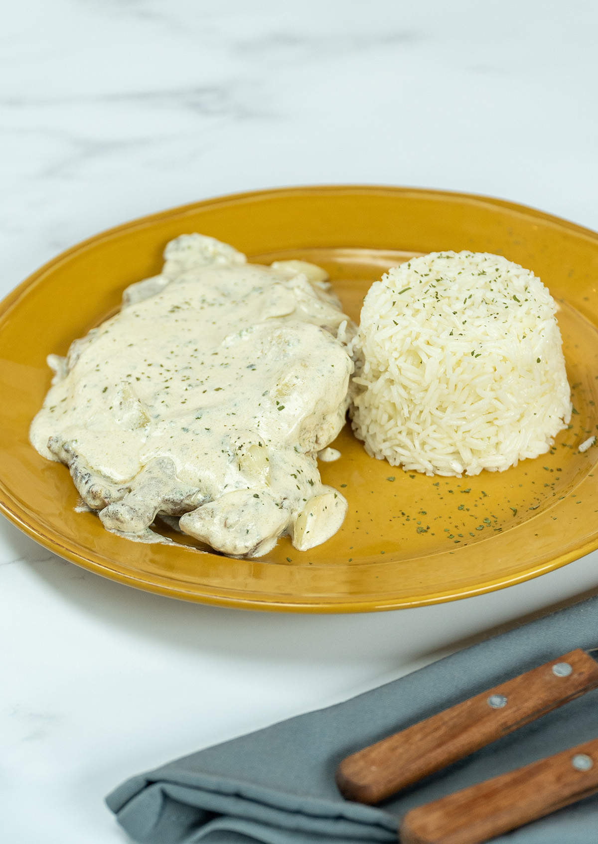 Empratamento bife ao molho de alho com arroz de acompanhamento.