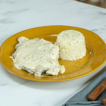 Empratamento bife ao molho de alho com arroz de acompanhamento.