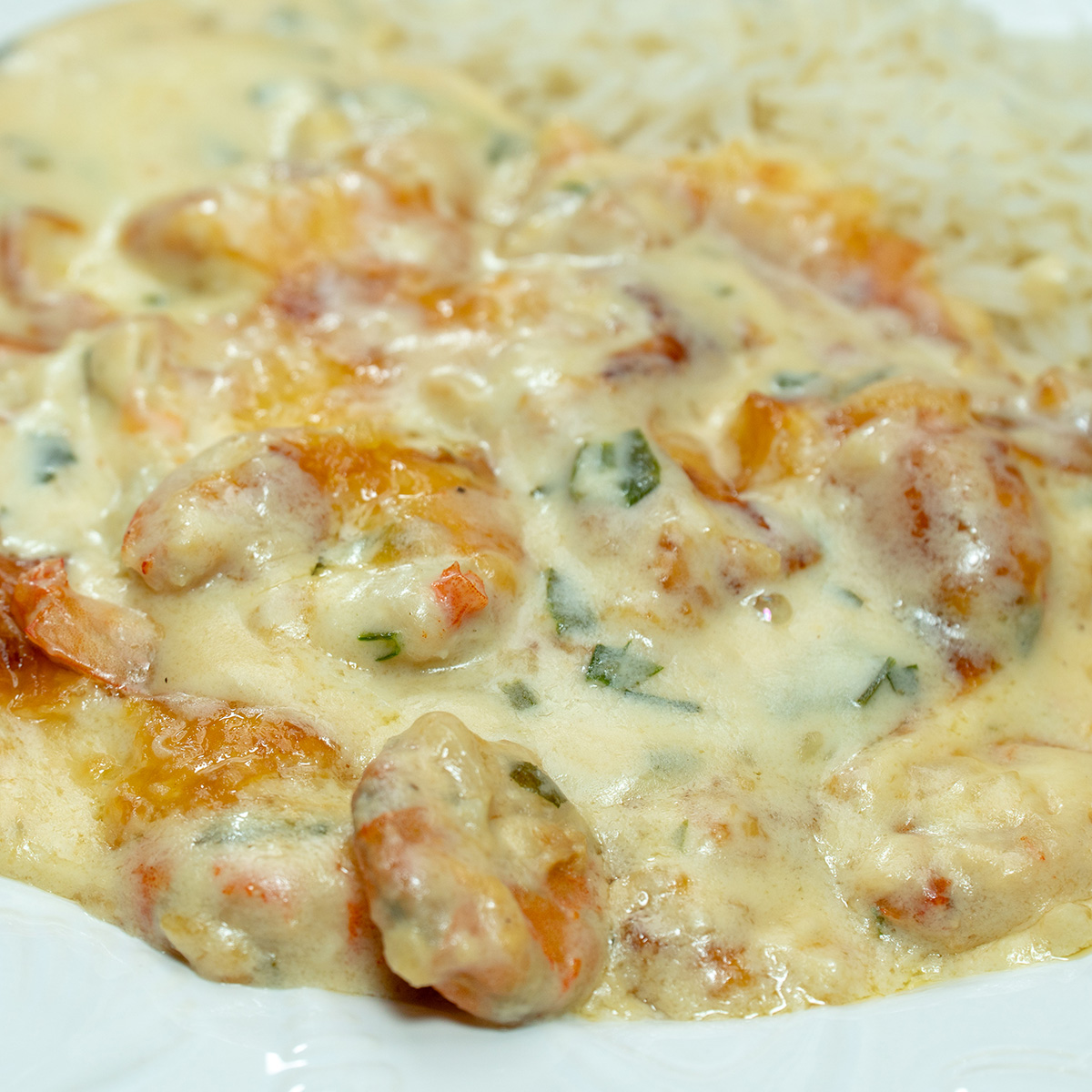 Empratamento camarão gratinado com arroz de acompanhamento.