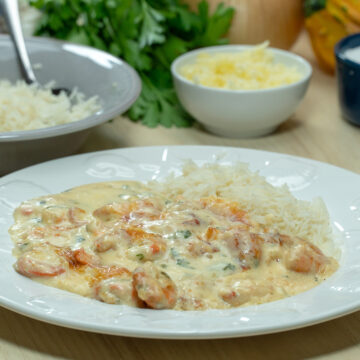 Empratamento camarão gratinado com arroz de acompanhamento.