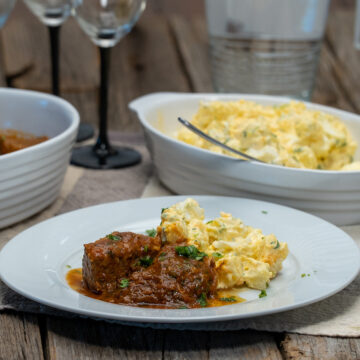 Empratamento carne cozida com salada de batata de acompanhamento finalizado coentro.