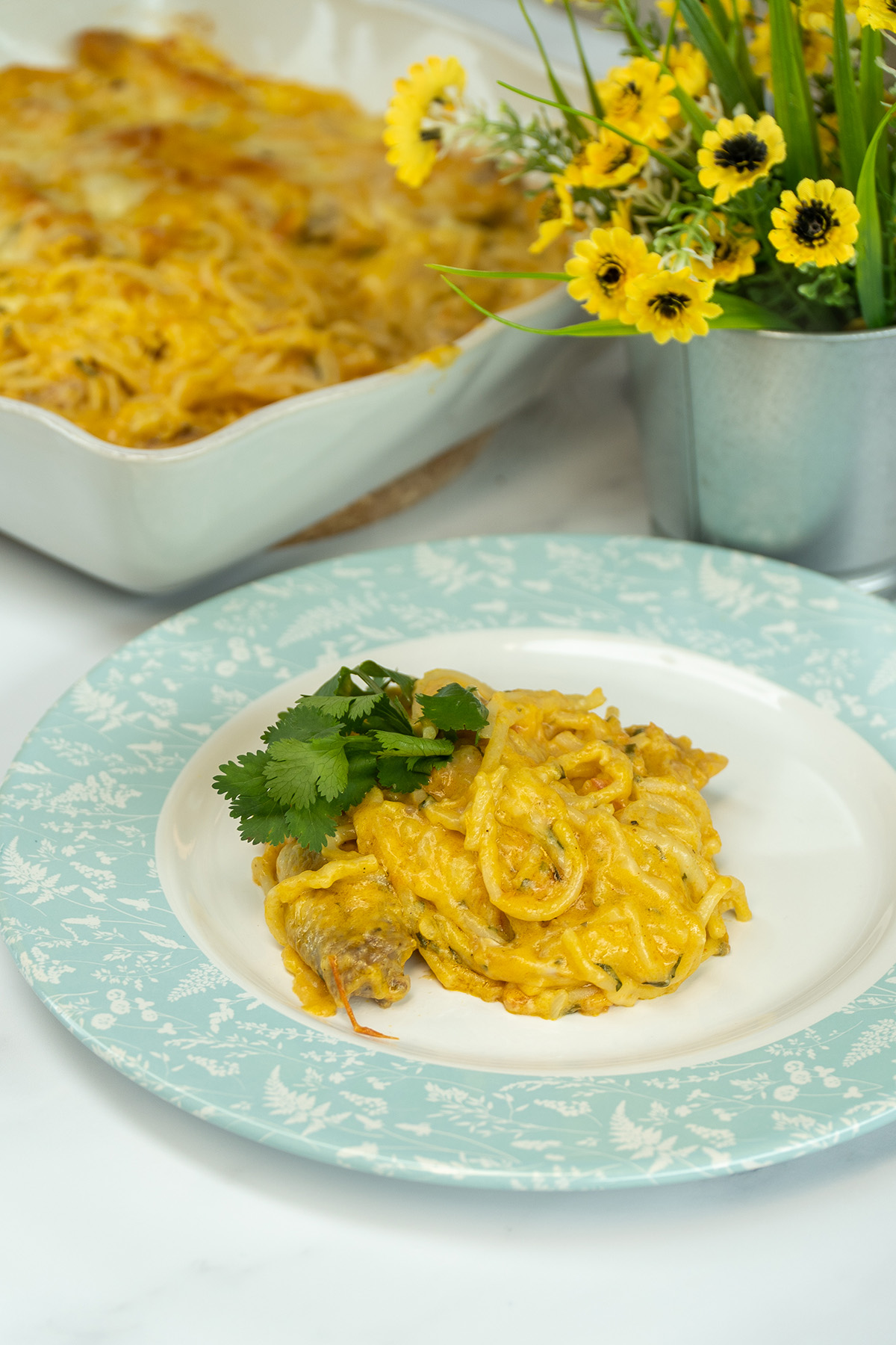 Empratamento espaguete gratinado com asinhas de frango com salsa de decoração.