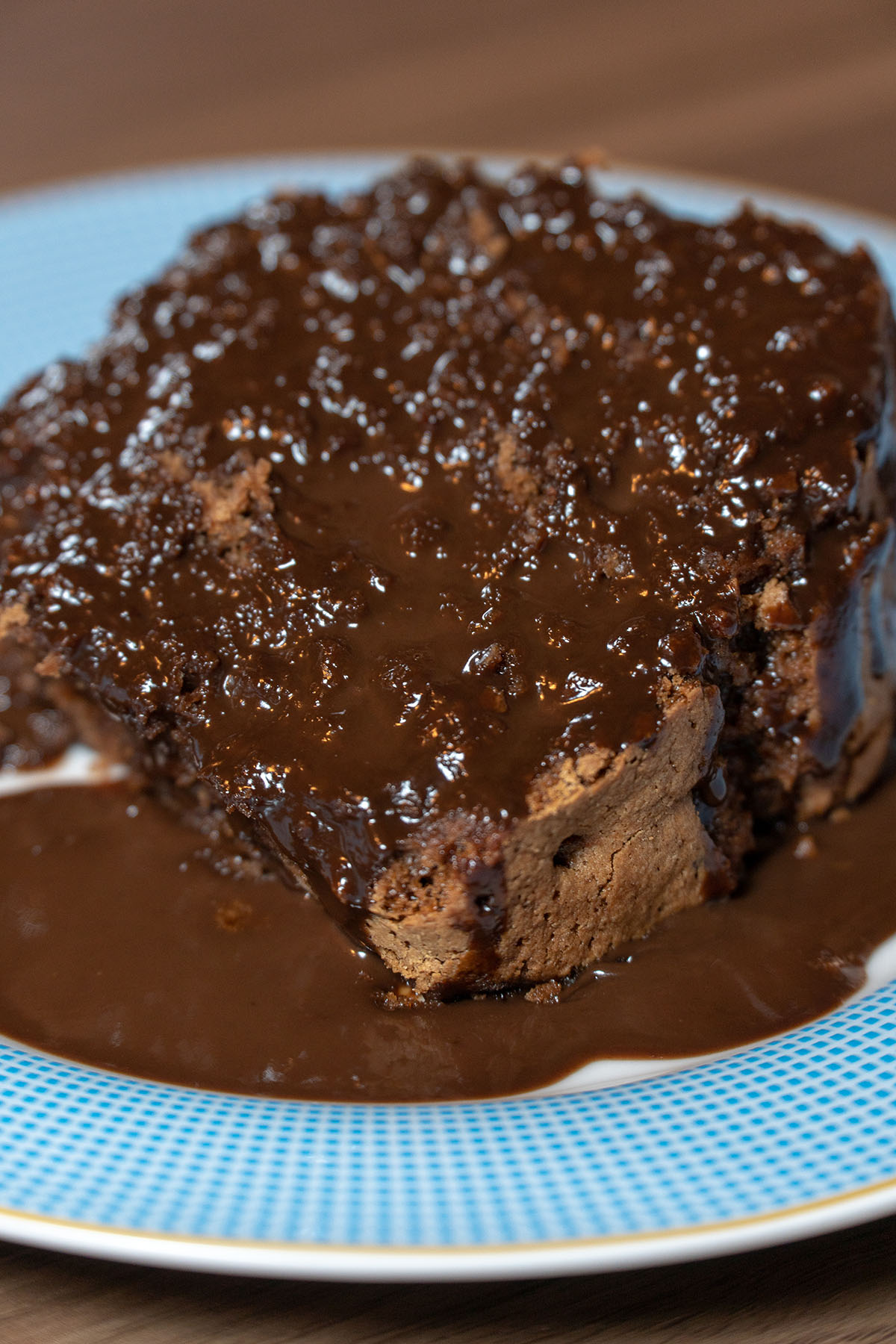Empratamento bolo de chocolate finalizado com calda de chocolate.