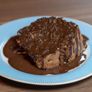 Empratamento bolo de chocolate finalizado com calda de chocolate.