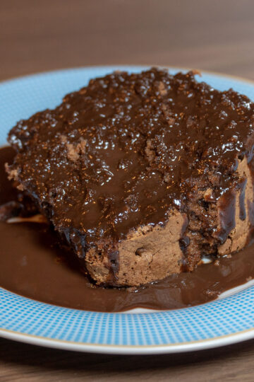 Empratamento bolo de chocolate finalizado com calda de chocolate.