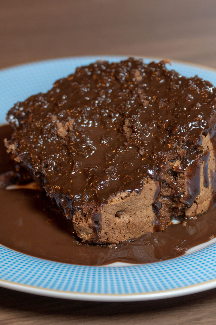 Empratamento bolo de chocolate finalizado com calda de chocolate.