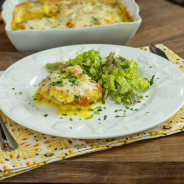 Empratamento filetes de pescada ao forno com molho branco e alface de acompanhamento.