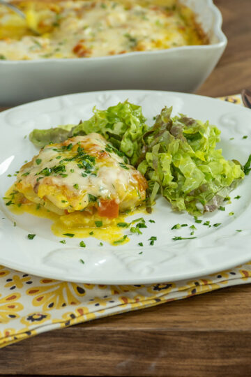 Empratamento filetes de pescada ao forno com molho branco e alface de acompanhamento.