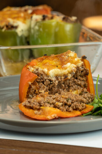 Empratamento pimentão recheado com carne moída cortado ao meio.