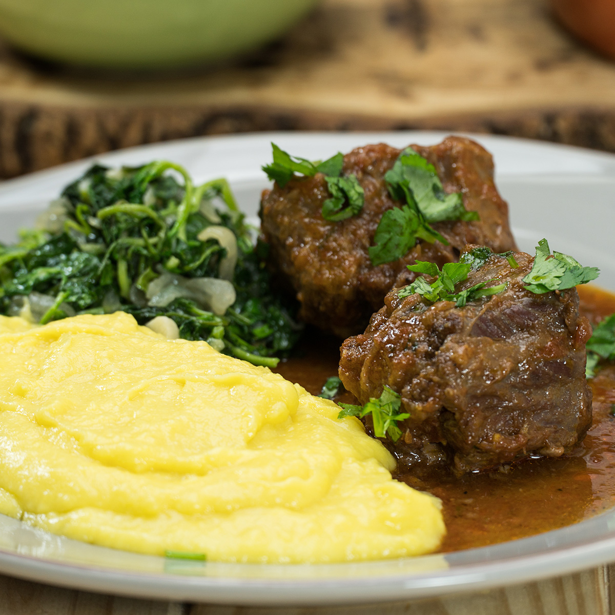 Empratamento rabada com polenta e agrião finalizada com salsa.