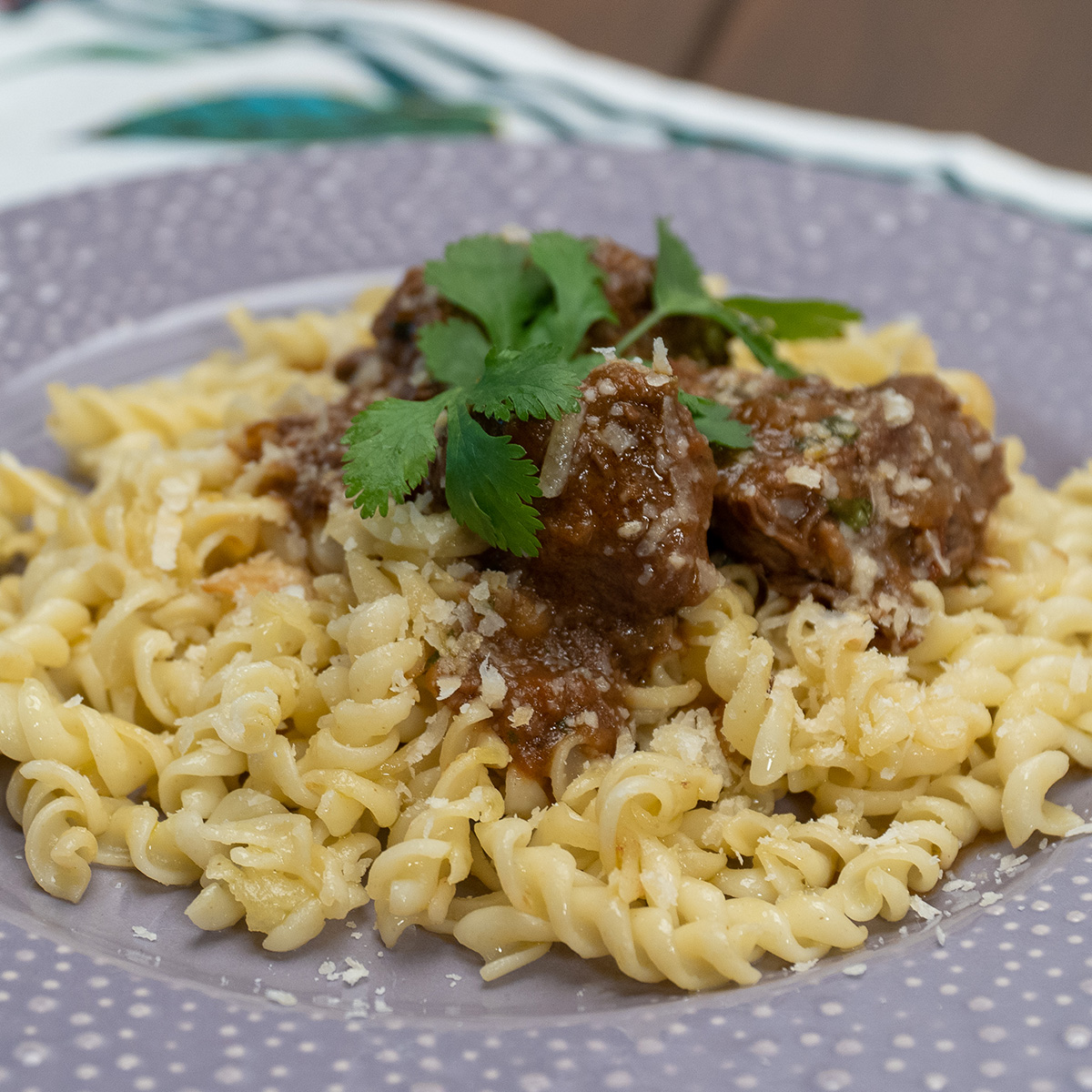 Ragu de carne com macarrão servido com queijo ralado e molho encorpado.