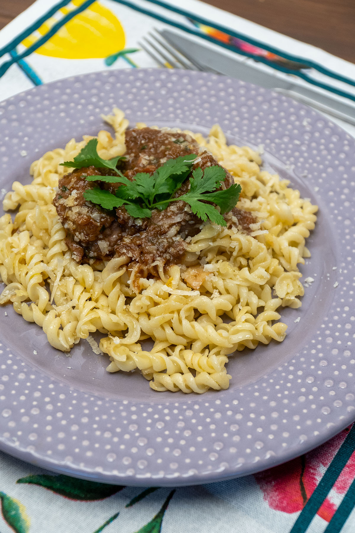 Ragu de carne com macarrão servido com queijo ralado e molho encorpado.