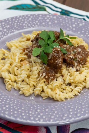 Ragu de carne com macarrão servido com queijo ralado e molho encorpado.