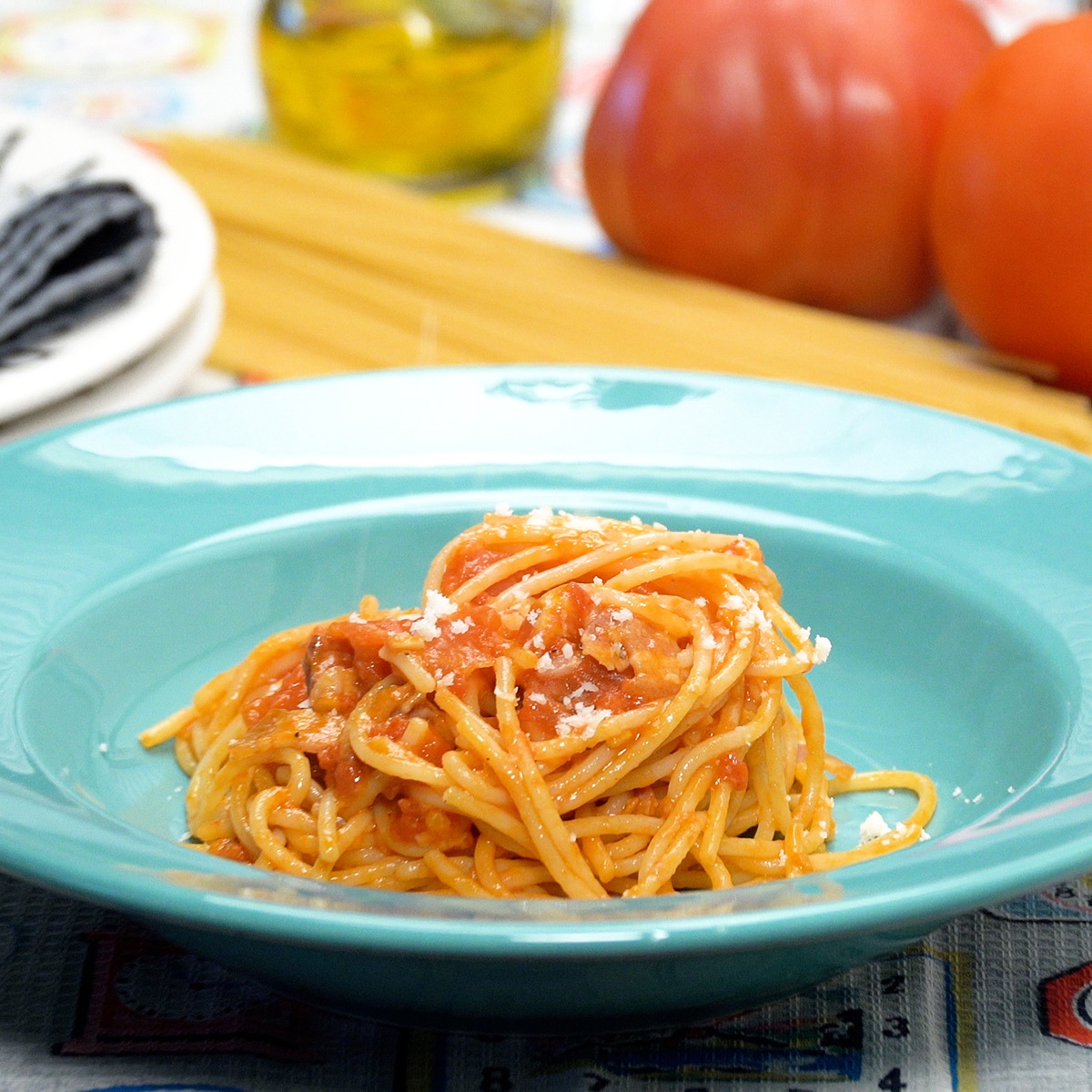 Espaguete amatriciana finalizado com um pouco queijo parmesão ralado por cima.