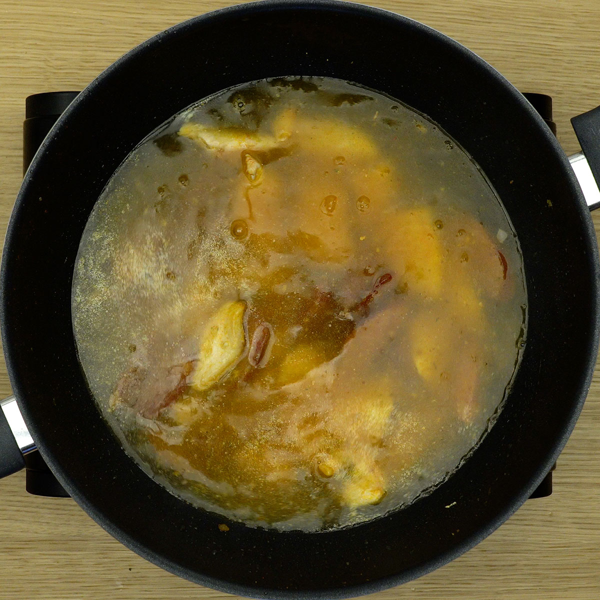 Caldo de galinha sendo misturado ao frango e calabresa.