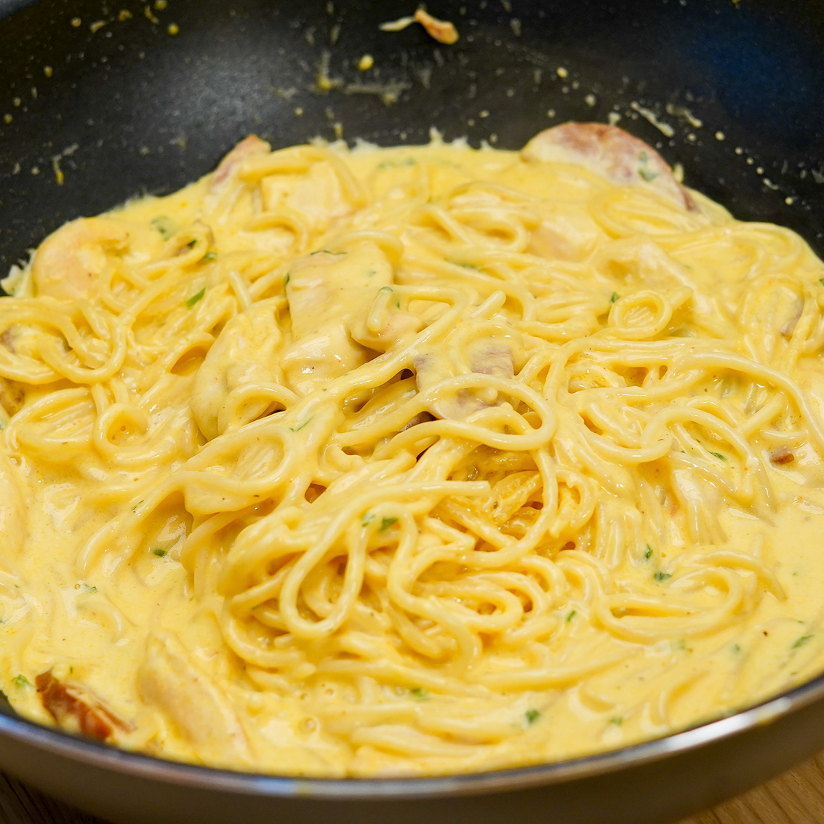 Espaguete com frango e calabresa ao molho cremoso pronto para ser servido.