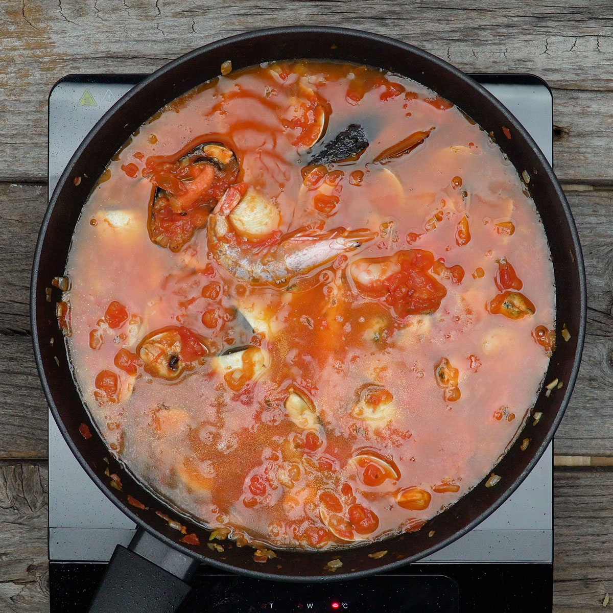 Molho de marisco cozinhando com água para intensificar sabor.
