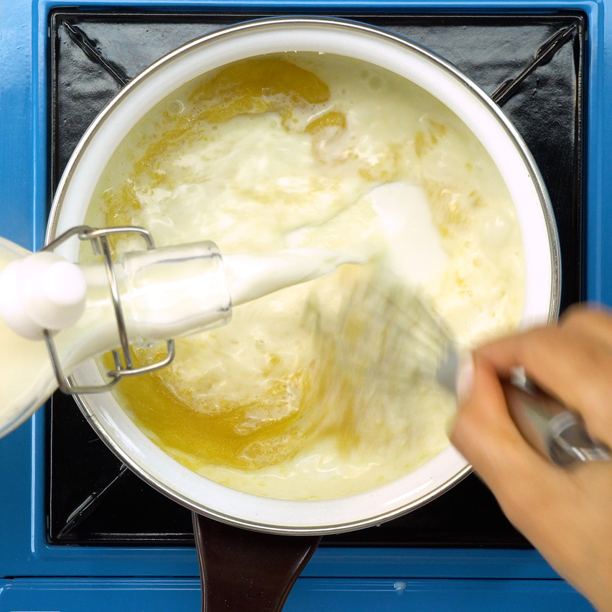 Molho branco cremoso sendo preparado para espaguete gratinado.