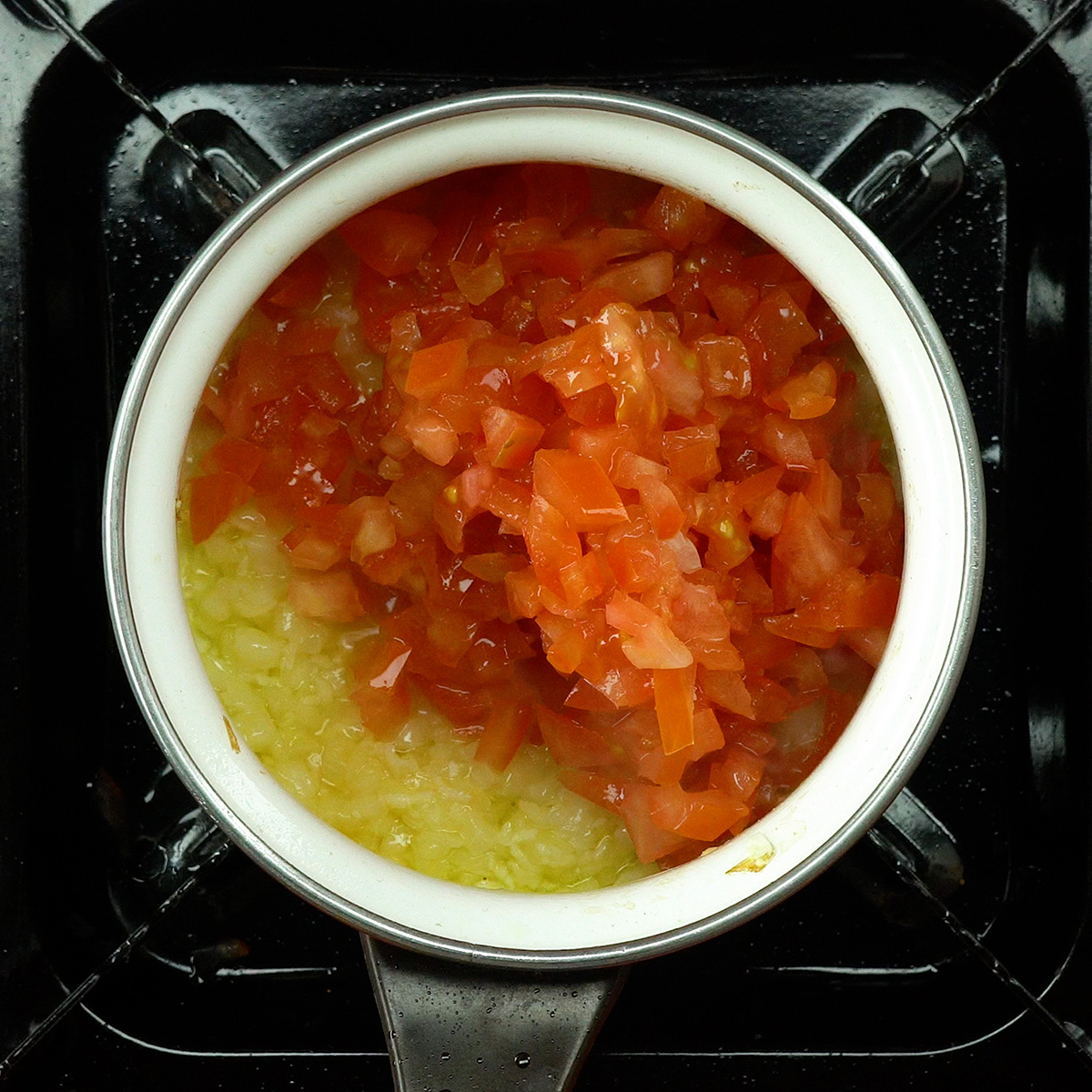 Tomate e cebola refogados formando molho caseiro para peixe ao forno.