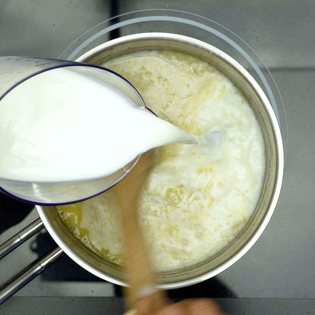 Molho branco sendo preparado com adição gradual de leite.