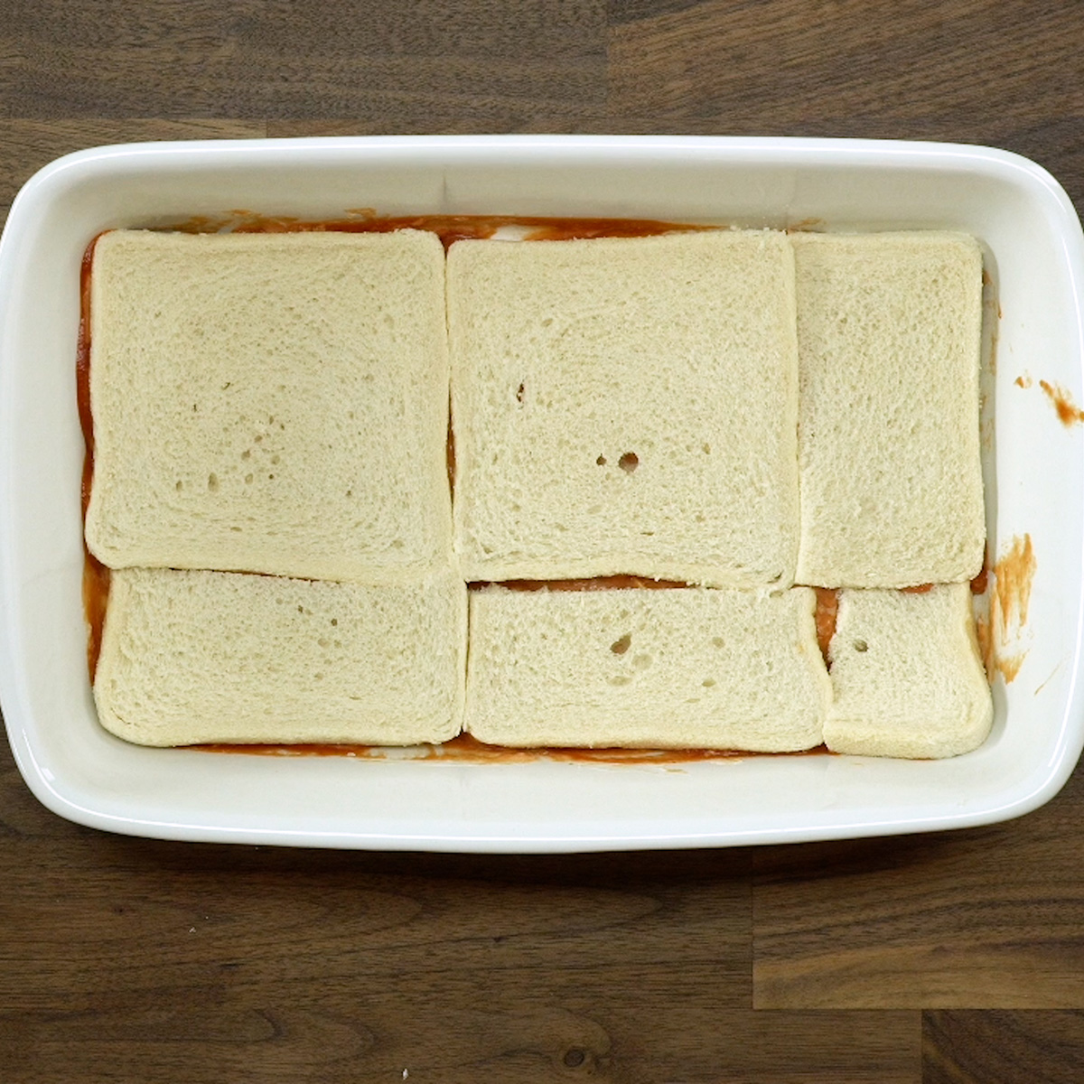 Camada de pão de forma organizada no refratário do lachão de pizza.