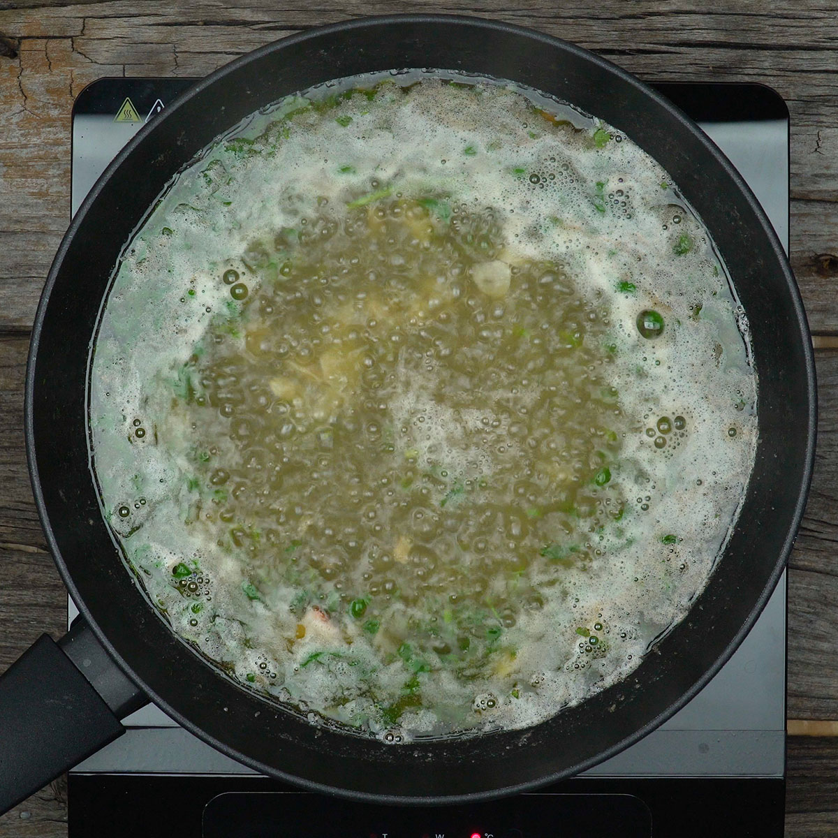 Molho aromático fervendo na frigideira.