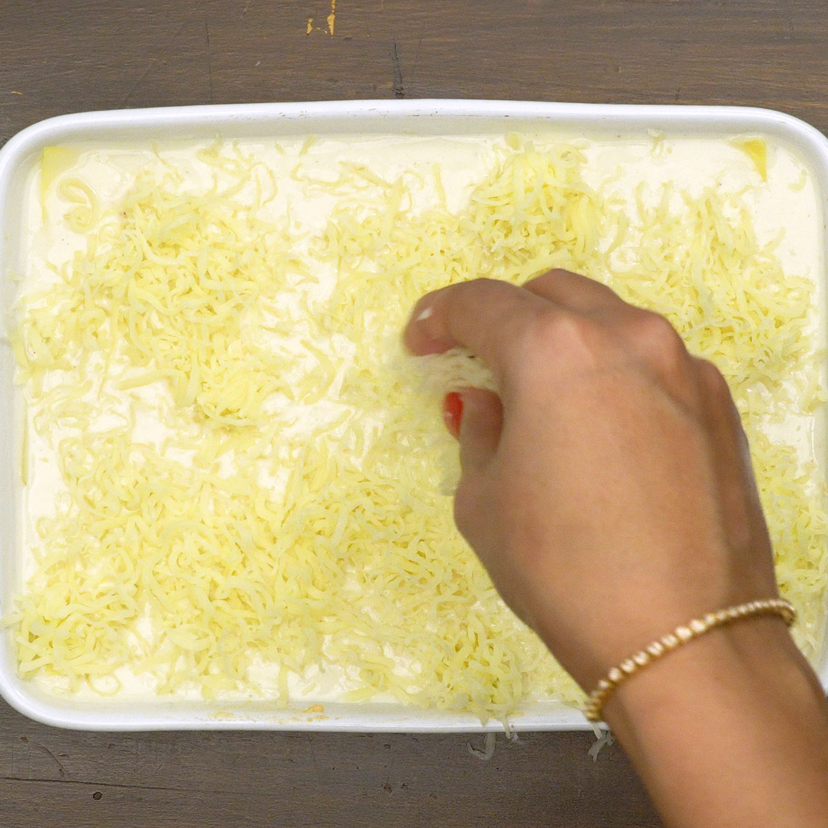 Lasanha de frango montada com queijo antes de assar.