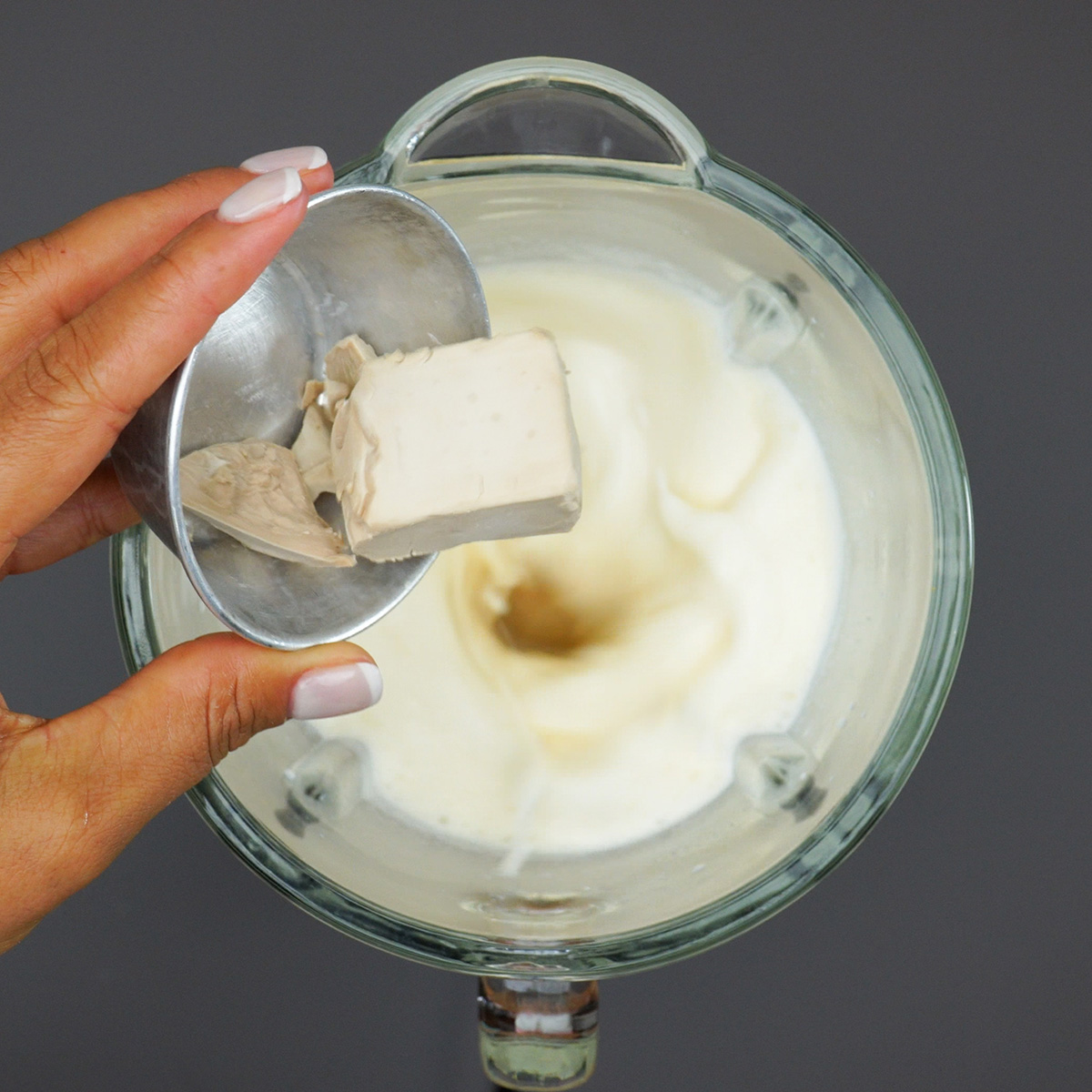Fermento biológico sendo misturado aos ingredientes líquidos da massa.
