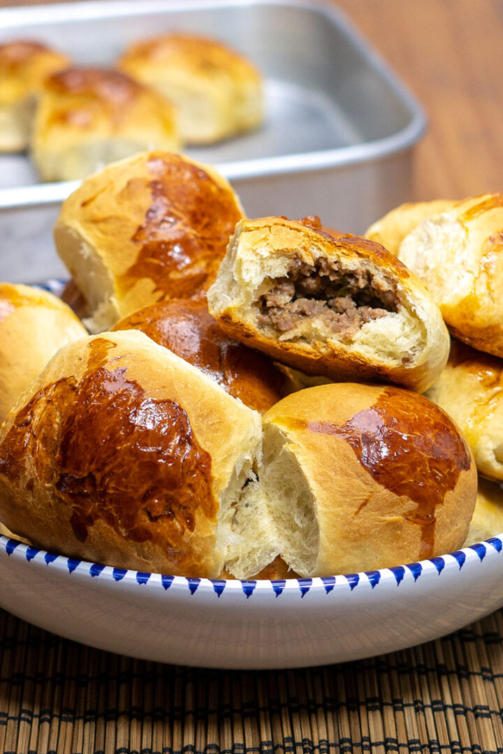 Pãezinhos assados recheados com carne moída prontos e sendo servidos.