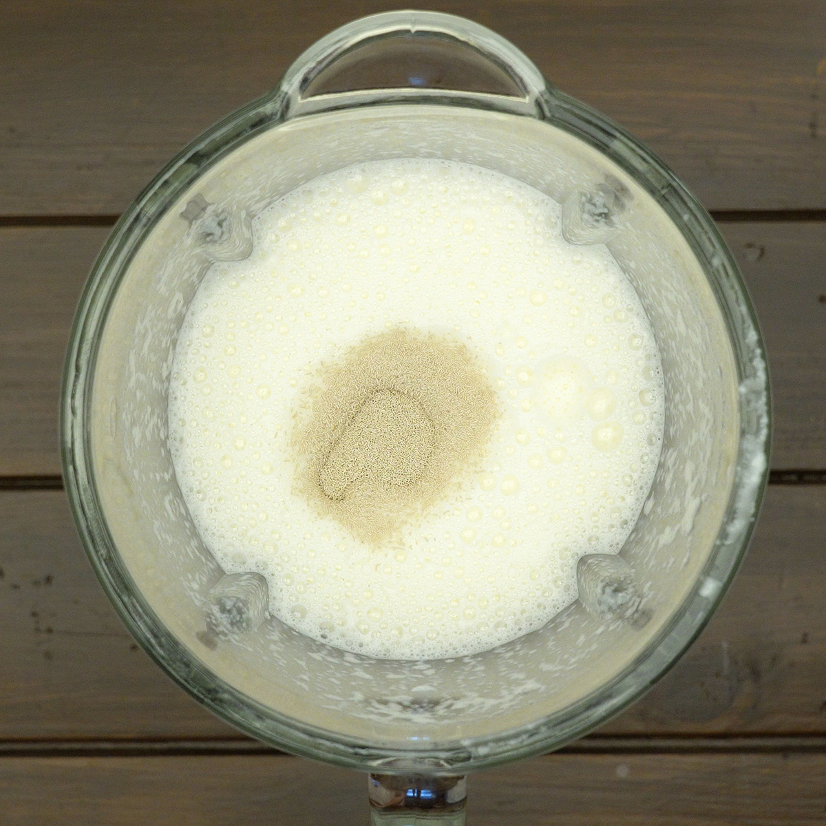 Fermento biológico seco sendo misturado à massa líquida do pão de cebola.