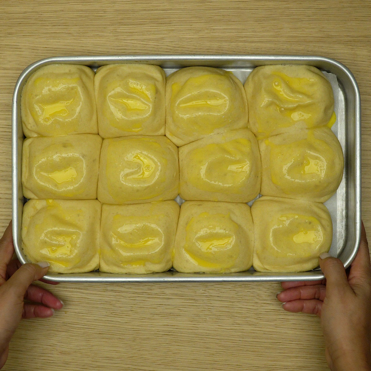 Pães de cebola lavados para assarem até ficarem dourados e macios.