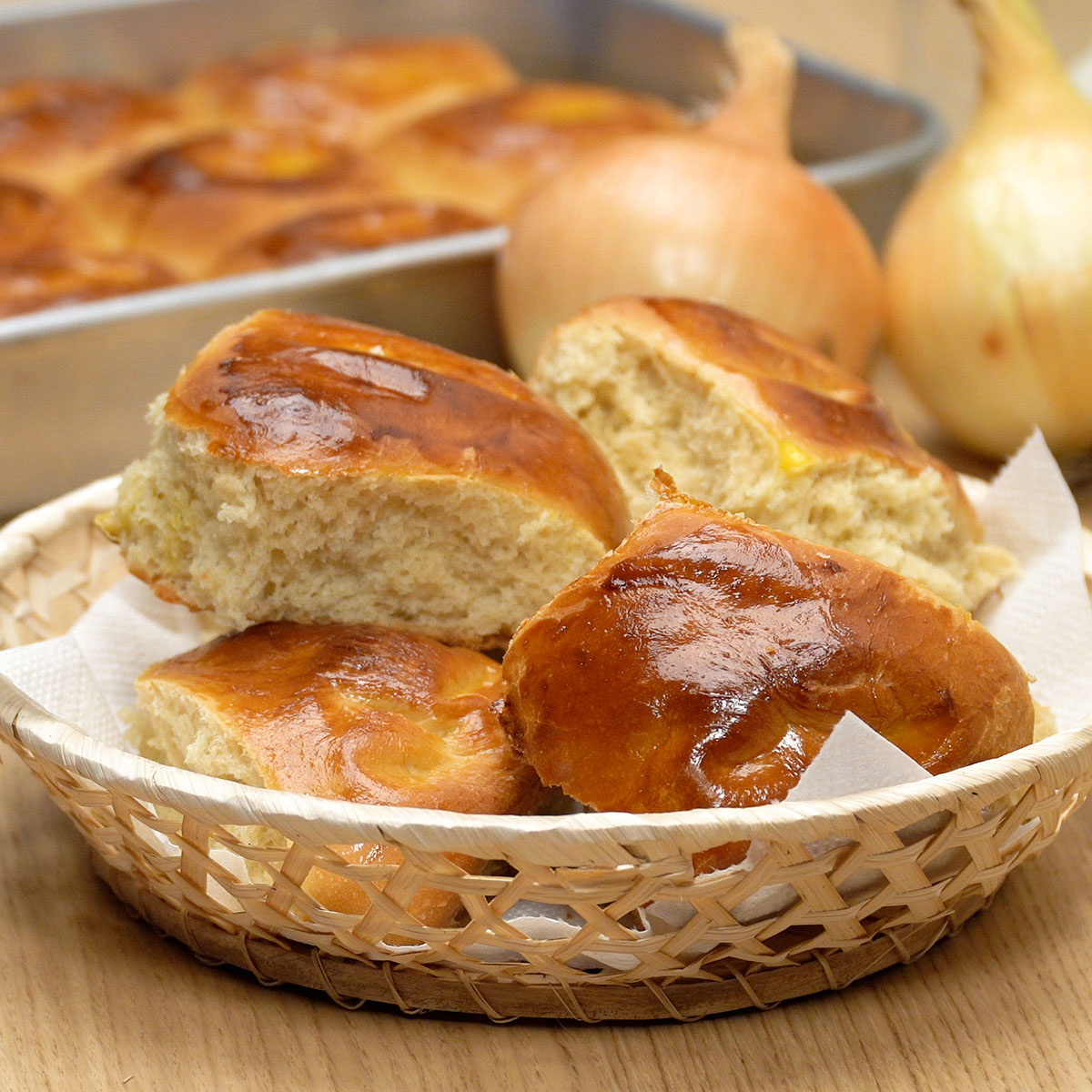 Pão de cebola caseiro servido ainda morno sobre mesa de café.