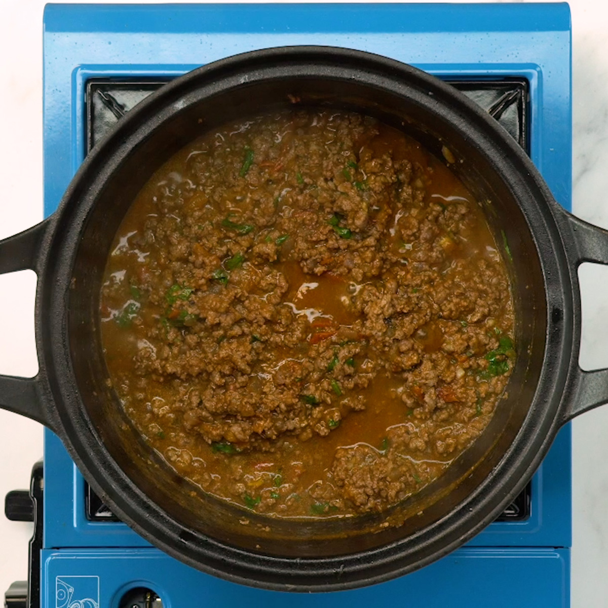 Recheio de carne com tomate e temperos cozinhando na panela.