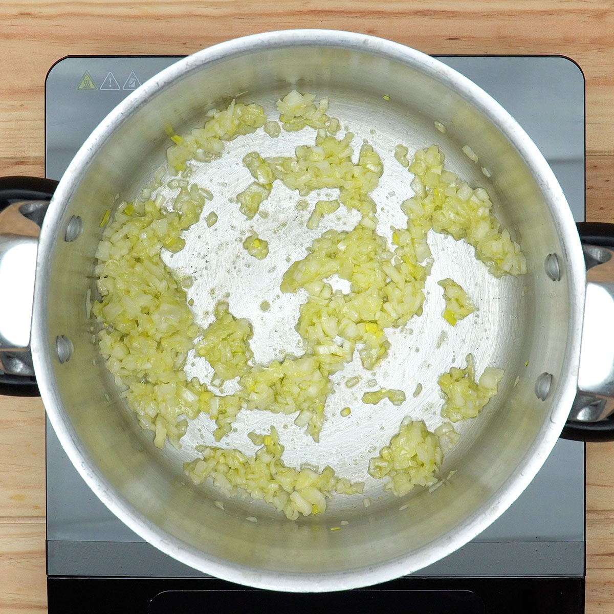 Cebola e alho sendo refogados para preparar rabada com polenta e agrião.