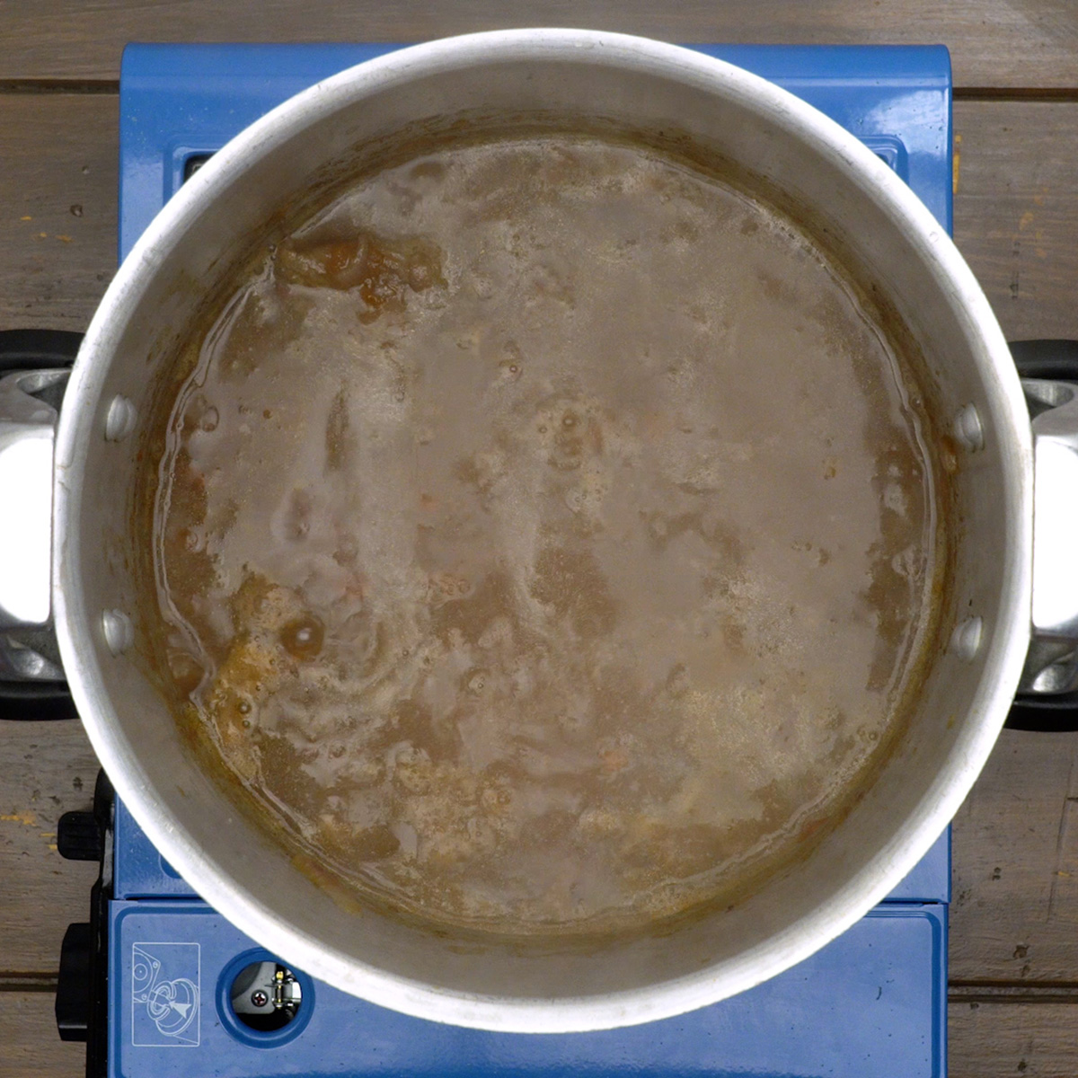Carne cozinhando na panela de pressão com molho ao vinho tinto.