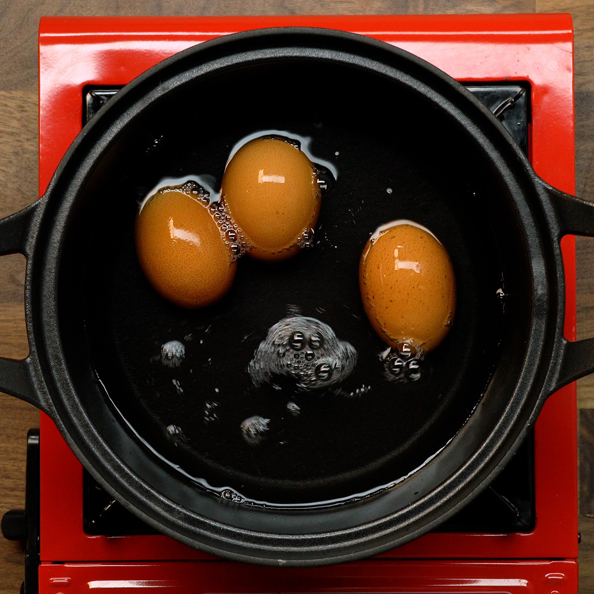 Ovos cozinhando em panela com água para preparar salada de maionese com legumes.