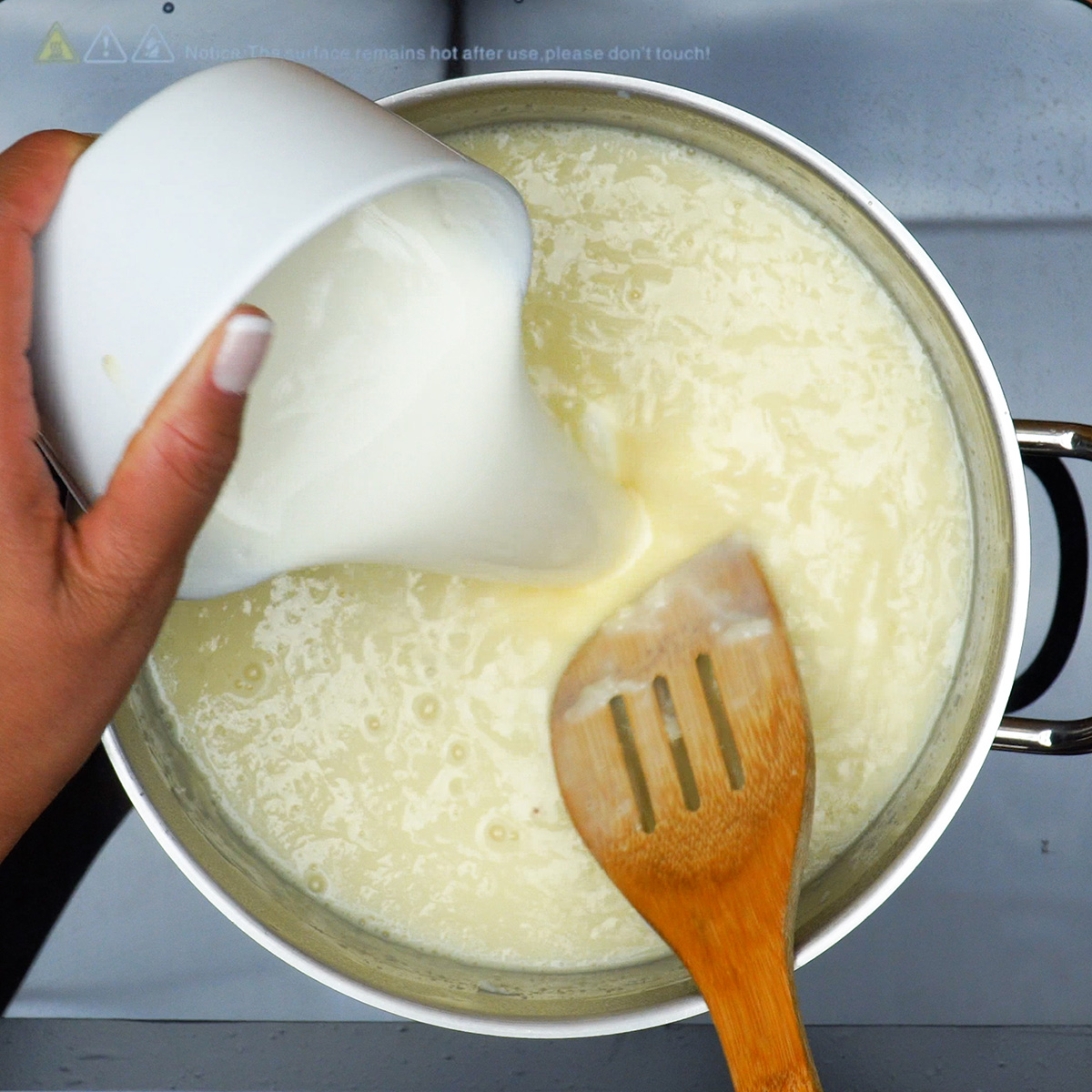 Creme de coco cremoso engrossando lentamente durante o preparo na panela.