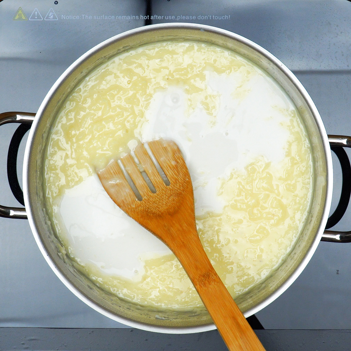 Ingredientes do creme de coco sendo misturados em panela antes do cozimento.