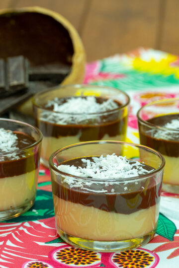 Sobremesa de coco com chocolate servida em taças com coco ralado de decoração.