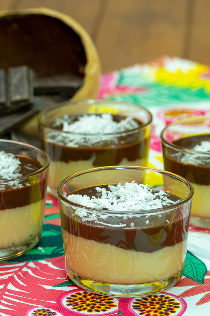 Sobremesa de coco com chocolate servida em taças com coco ralado de decoração.