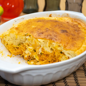 Torta cremosa de frango com batata sendo servida em fatias.