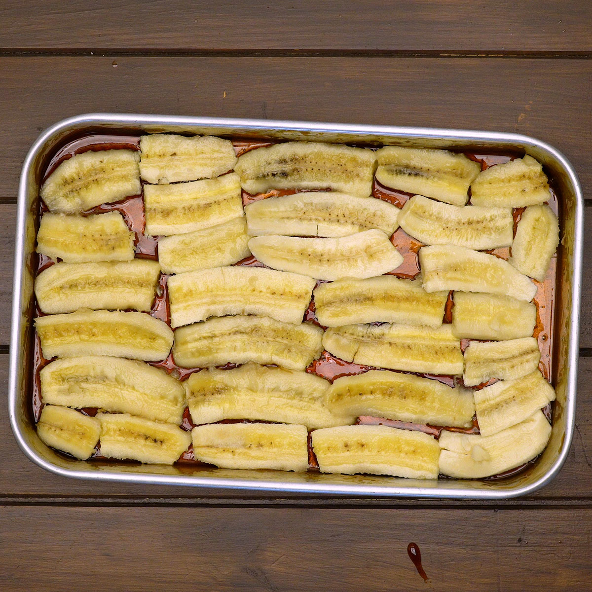 Bananas organizadas sobre o caramelo na forma da torta.